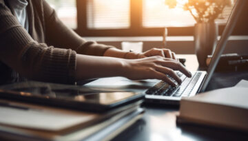 A businesswoman sitting at desk, using laptop generated by AI