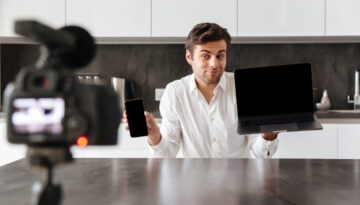 Smiling young man filming his video blog episode