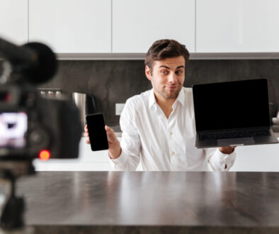 Smiling young man filming his video blog episode